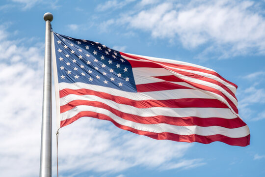 American flag against a blue sky backdrop. consists of 13 horizontal stripes, seven red and six white, and a blue rectangle with 50 white stars in the top left corner, forming a rectangular triangle