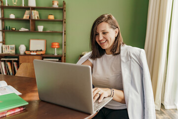 An architect is a female designer working online designing a new startup, using a laptop on a desk. A workplace in a stylish office.