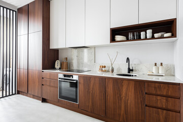 Modern kitchen with wood cabinetry covering fridge freezer dishwasher 