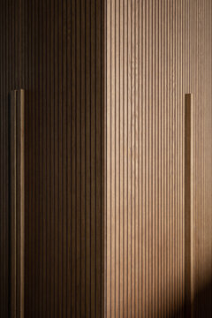 Wardrobe detail with vertical lines, direct light, hard shadow texture