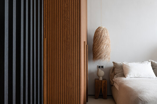 Wood furniture with vertical lines in bedroom with natural materials