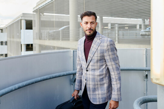 Stylish man walking up parking garage stairs