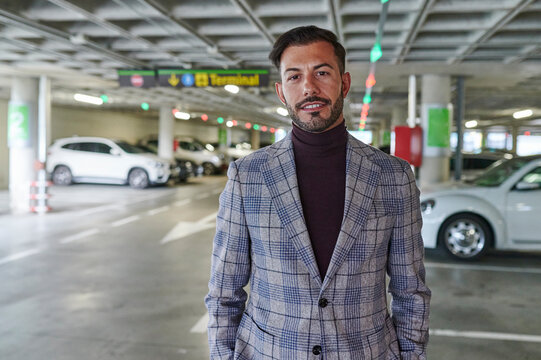 Stylish man standing in an airport parking lot