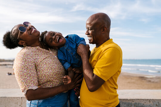 Happy black family having fun on beach