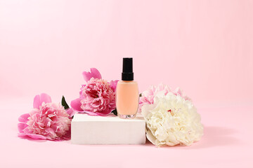 Spa and wellness composition with cosmetic bottle and peony and rose flowers on elegant premium...