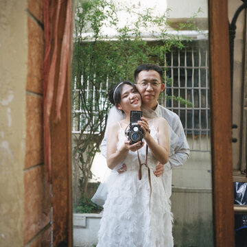 Couples holding dual reflex cameras taking selfies

