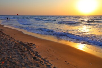 Fototapeta na wymiar Sunset on Dado Beach in Haifa. Sandy beach in Haifa, Israel.
