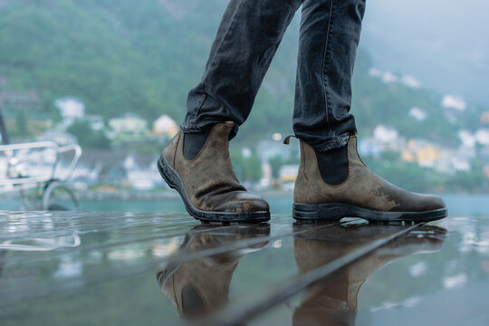 Close Up Of Man In Leather Shoes Walking On The Wet Pier Near Fjord