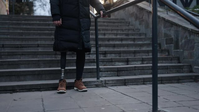 Disabled access, Functional prosthetic, Climbing acceptance. Prosthetic leg-wearing man with disability ascends stairs on city street.