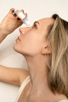 Woman instilling eye drops