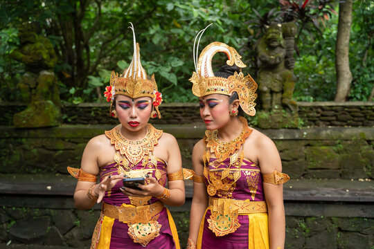 Traditional Bali Dancers Using Phone In The Park