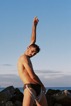 Male ballet dancer posing on the beach at sunset