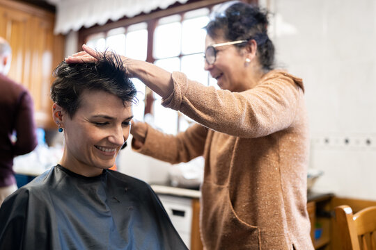 woman cutting another woman's hair at home
