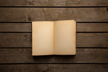 Vintage book, open, on old wooden table, with clipping path. Open Book blank on old wooden...