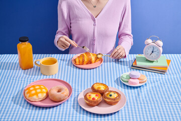 A young woman is enjoying her breakfast with something sweet.