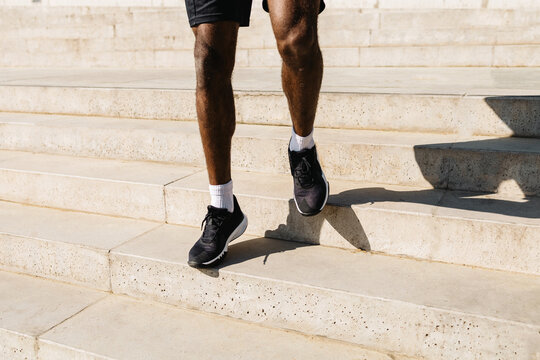 close-up of the legs of a man running up the stairs