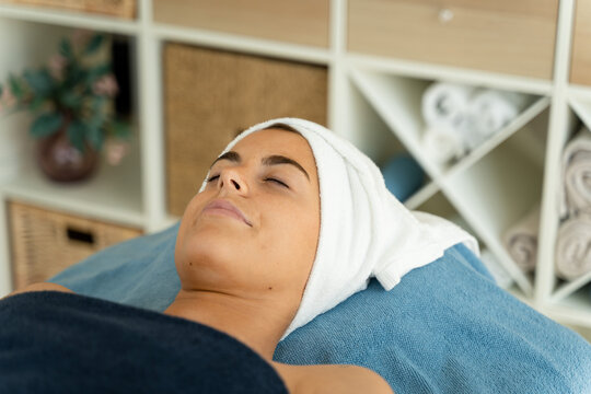 Woman is lying in a spa with her eyes closed.