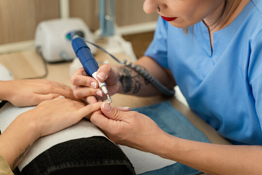 Manicurist doing gel nails for a client.
