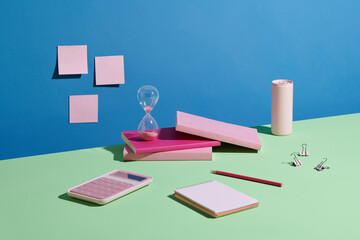 hourglass and books on green table