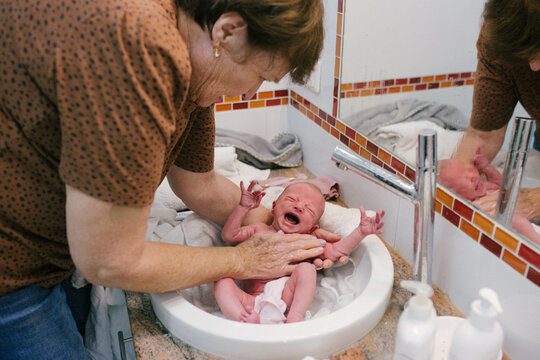 Grandmother giving first baby bath