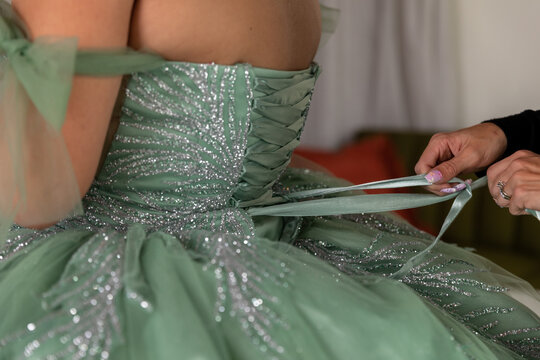 Girl Getting Gown Laced up for Quinceanera
