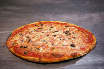 pizza margherita appena uscita dal forno su di una base di acciaio di una pizzeria