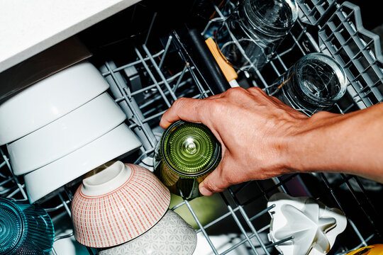 man takes a glass from the dishwasher
