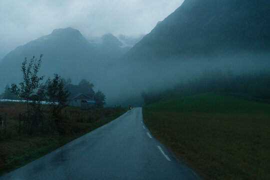 Road in mountain covered with fog at twilight 