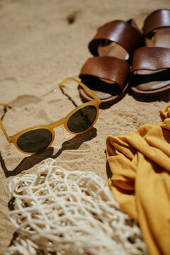 Composition with beach accessories and flip-flops on the sand