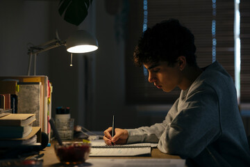 Teenage male studying late night at home