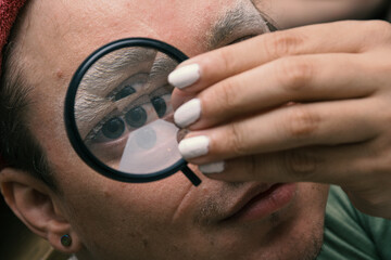 Man doing his make up with a caleidoscopic filter con his eye