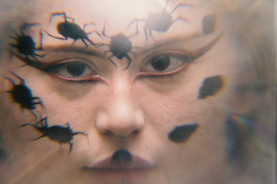Artistic concept portait of a young woman with spiders make up