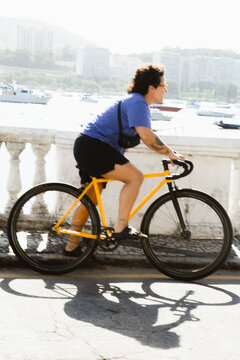 Woman riding a bike by the waterfront