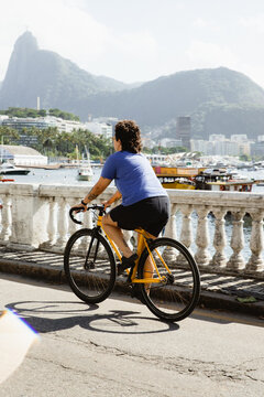 Woman riding a bike with a view of Christ The Redeemer