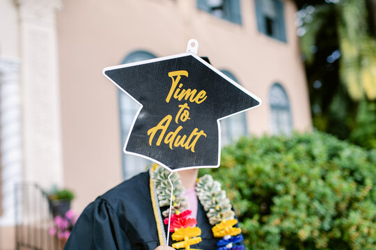 Teen with banner on his graduation day