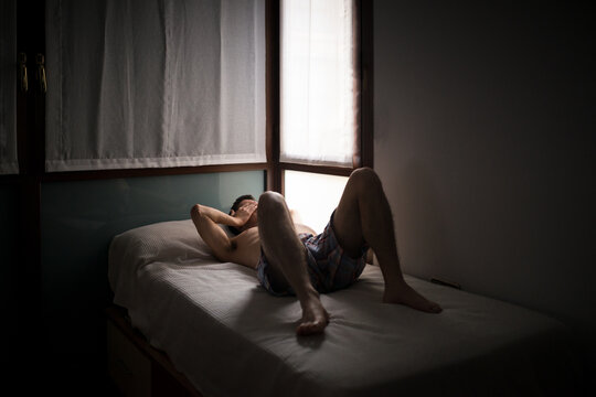 Lazy teenage man lying on bed