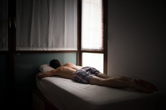 Anonymous teen sleeping on dark bedroom