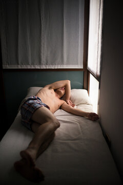 Young man feeling depressed and anxious on bed