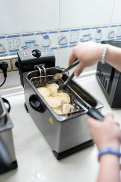Frying empanadas in deep fryer.