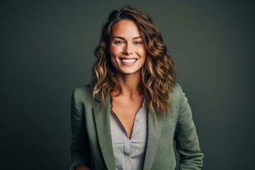Fototapeta premium Portrait of a smiling businesswoman standing with arms crossed against grey background