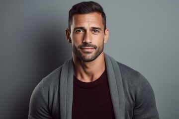 Obraz premium Portrait of handsome young man in grey sweater looking at camera.