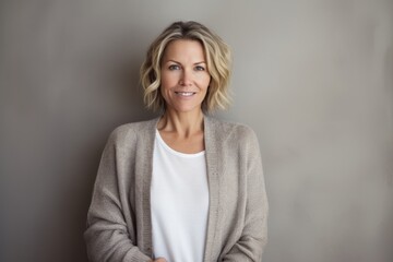 Portrait of beautiful middle aged woman with short blond hair, wearing casual clothes, looking at camera.