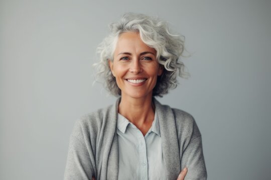 Portrait of smiling senior woman with grey hair. Isolated on grey background