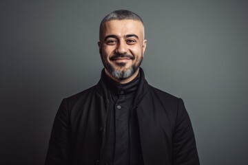 Obraz premium Portrait of a handsome man in a black jacket on a gray background