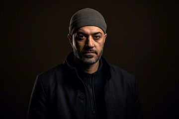Obraz premium Portrait of a bearded Indian man wearing a black jacket and a hat