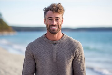 Lifestyle portrait photography of a satisfied man in his 30s wearing a cozy sweater against a beach background