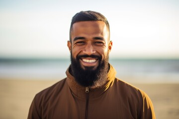 Portrait of a handsome young man smiling while standing on the beach