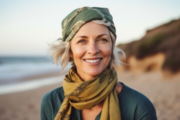 Portrait of smiling mature woman wearing headscarf on the beach