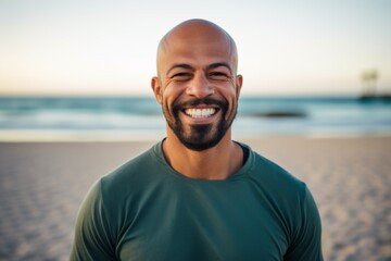 Lifestyle portrait photography of a grinning man in his 40s wearing hijab against a beach background