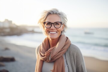 Lifestyle portrait photography of a satisfied woman in her 50s wearing a chic cardigan against a beach background